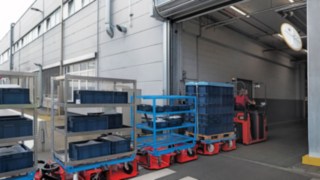 O comboio logístico LT10 WX da Linde MH transporta material entre dois armazéns