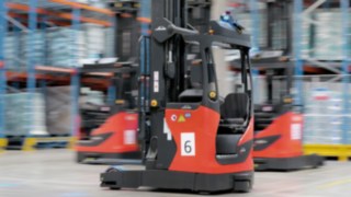 Três empilhadores retráteis automatizados da série R-MATIC da Linde MH em operação.