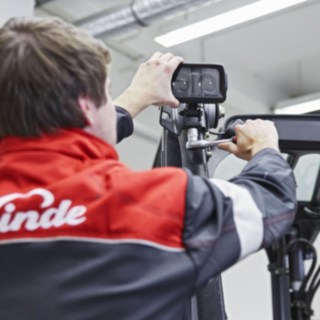Um mecânico da Linde Material Handling fixa um Linde BlueSpot ao tejadilho de um equipamento.