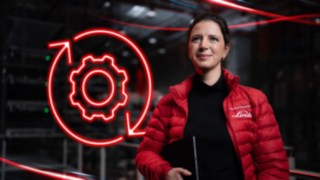 Colaboradora da Linde Material Handling num armazém, com um símbolo LED vermelho de uma roda dentada em segundo plano.
