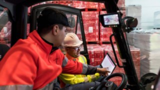 Um especialista em segurança da Linde MH mostra dados a um condutor de empilhadores num tablet. Um especialista em segurança da Linde MH mostra dados a um condutor de empilhadores num tablet.