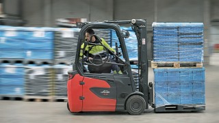 Um colaborador da DB Schenker a fazer marcha-atrás no empilhador elétrico Linde E16 Um colaborador da DB Schenker a fazer marcha-atrás no empilhador elétrico Linde E16