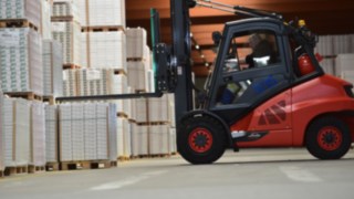 Empilhador com motor de combustão a empilhar materiais Empilhador com motor de combustão a empilhar materiais