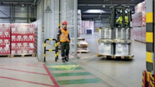 A Heineken Suíça foi uma das primeiras empresas a decidir utilizar o sistema de assistência Linde Safety Guard. Um peão atravessa-se no trajeto de um empilhador que está a virar e aparece um símbolo de aviso no chão do pavilhão à sua frente.