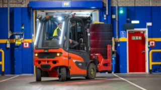 Um colaborador da Michelin Tyre PLC desloca-se em marcha-atrás num empilhador da Linde Material Handling.