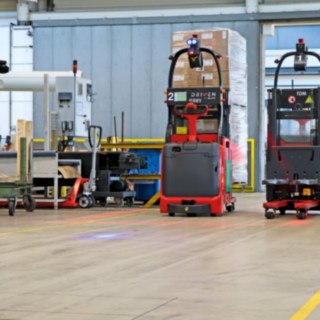Dois stackers automáticos L-MATIC transportam mercadorias entre a linha de embalamento e o armazém dinâmico.