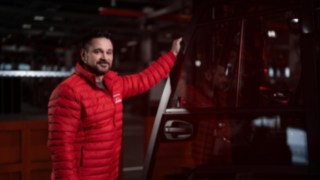 Um colaborador da Linde Material Handling está ao lado de um equipamento de movimentação de cargas e sorri para a câmara.