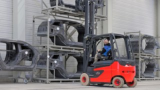 O empilhador da Linde dirige-se para uma estanteria com partes de carroçaria