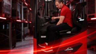 Vista lateral de um operador a trabalhar no ergonómico empilhador retrátil Ri16 da Linde MH.