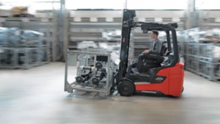 Um grupo de pessoas a analisar o ambiente de trabalho num pavilhão logístico.