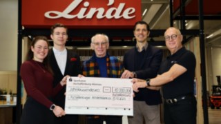 Donativo de Staplercup hilft e. V. para a instituição Aschaffenburger Kinderträume Cinco pessoas seguram um grande cheque emitido pela Linde destinado à Aschaffenburger Kinderträume no valor de 10 000 euros.