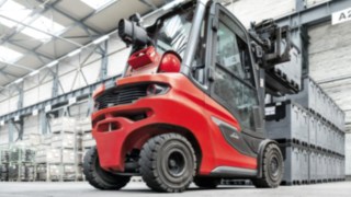 Os H20 – H35, que estão disponíveis como empilhadores a diesel e gás, são a resposta ideal para as exigências do moderno fluxo de material. O empilhador de motor de combustão H35 da Linde Material Handling a empilhar caixas